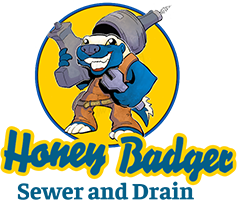 Cartoon honey badger holding plumbing tools, wearing brown overalls, with "Honey Badger Sewer and Drain" written below in yellow and blue text.